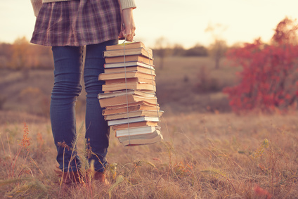 Hipster girl holding a stack of books